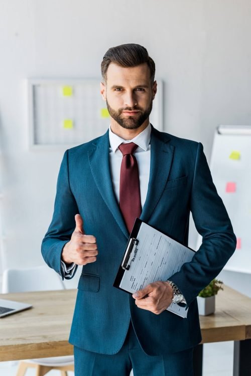 handsome-recruiter-standing-and-holding-clipboard-QRBW8R4.jpg
